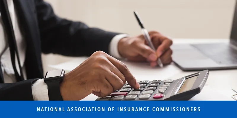 Man typing on calculator and writing down numbers.