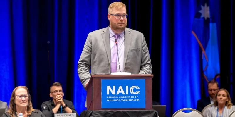 Jon Godfread delivers speech from the podium for the NAIC 2025 Summer National Meeting opening session.