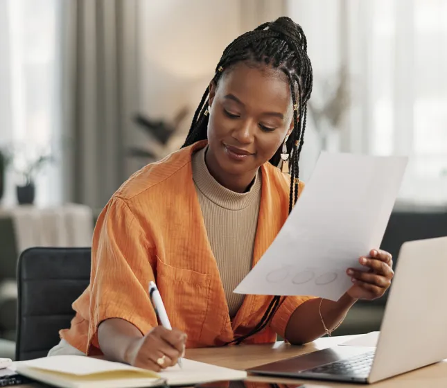 Woman writing and holding paperwork