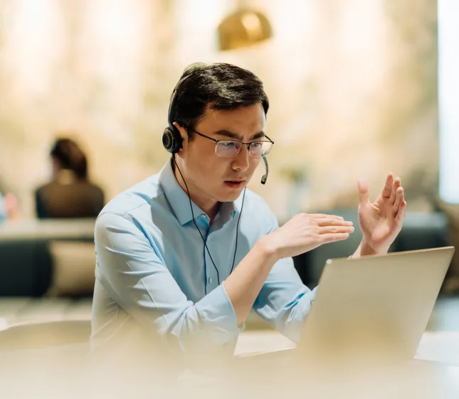 Man on laptop headset talking