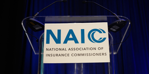 White Sign with Blue NAIC Logo from Podium at the 2023 NAIC International Insurance Forum